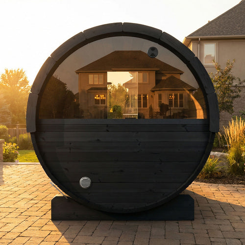 SaunaLife E7WB black barrel sauna on a patio at sunset, showing semicircular rear window.