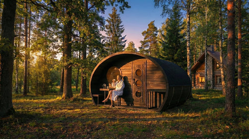 SaunaLife G11B black oval sauna suite in woodland with bathers.