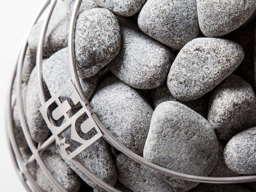HUUM DROP top-down close-up of rounded stones and HUUM badge.