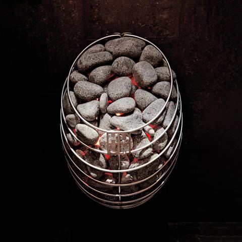 HUUM DROP stone-filled heater glowing against a dark wall.