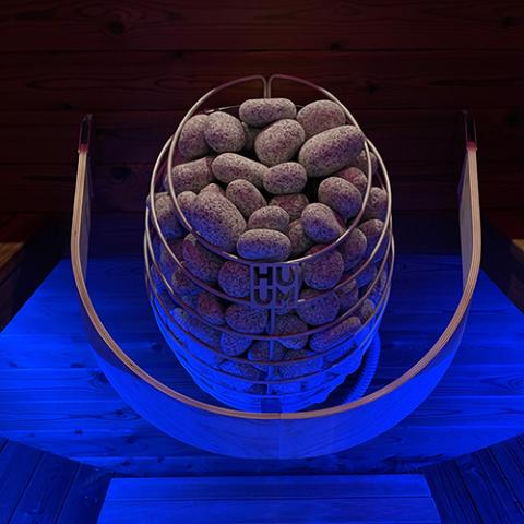 HUUM DROP heater below a curved wooden safety rail with blue accent lighting.