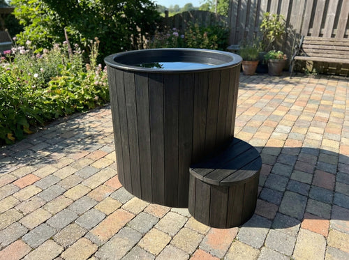 SaunaLife S1B black immersion tub and step on an outdoor patio.