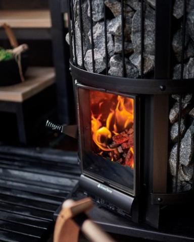 Close-up of a glowing fire behind the glass door of a Harvia Legend GreenFlame stove.