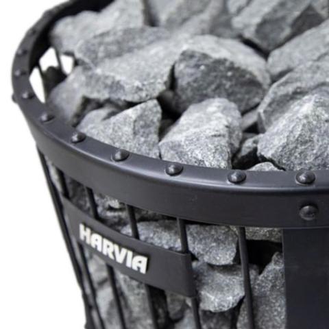 Close-up of stones, riveted rim and the Harvia logo on a Legend GreenFlame stove.