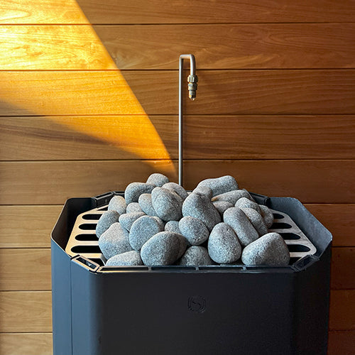 Saunum auto Leil water outlet over stone-filled Air Perfect heater.