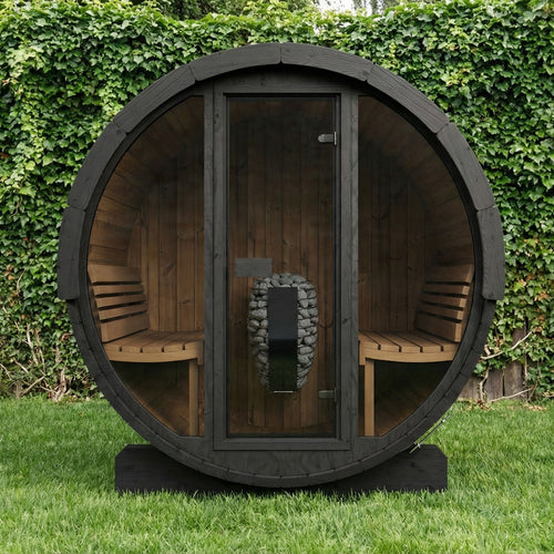 SaunaLife E7GB black barrel sauna on a lawn beside an ivy-covered fence.