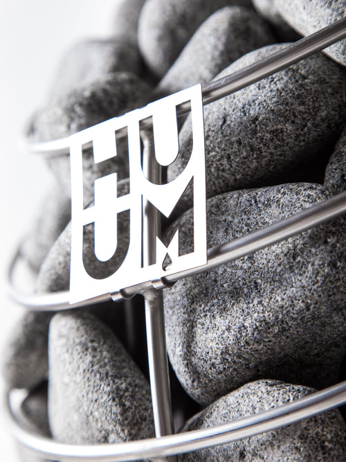 HUUM DROP close-up of HUUM logo and stones inside the metal basket.