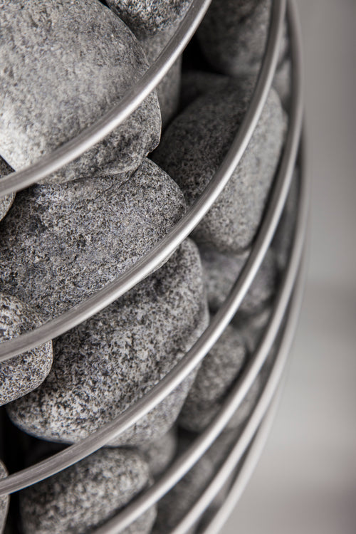 HUUM DROP close-up of rounded stones and curved basket rails.