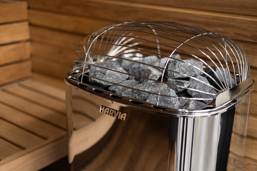 Close-up of the Harvia Club heater's polished casing, logo, stones and top guard.