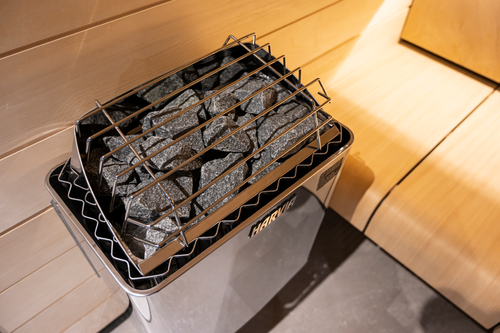 Close-up of stones and the metal top guard on an installed Harvia KIP heater.