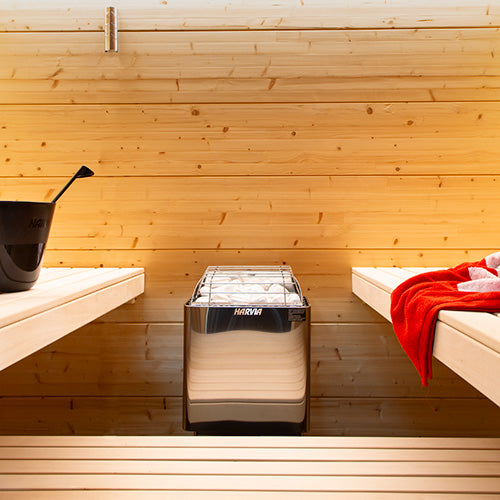 Harvia KIP W-series stainless-steel heater mounted between sauna benches.