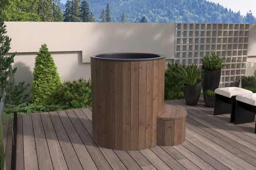 SaunaLife S1N natural-wood immersion tub beside a garden wall.