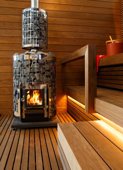 Harvia WL300PC stone-filled chimney cover above a Cilindro stove in a warmly lit sauna.