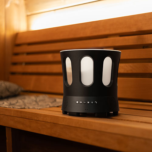 SaunaLife Zone - Bluetooth bucket beside sauna stones